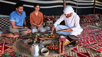 Three people from the UAE sit for traditional meal together