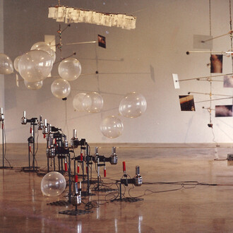 Frédéric Lecomte, Shooting gallery, 1993, 26 sèche-cheveux modifiés, ballons de baudruche imprimés en noir et blanc, serre-joints, socle en acier, Dimensions variables © l’artiste