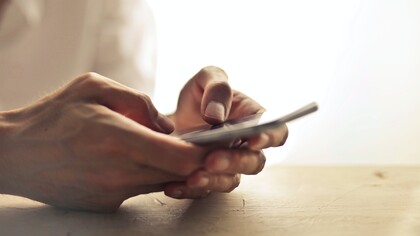 A person holding a mobile phone in their hands 