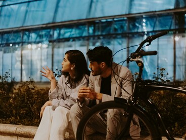 A couple sitting together on the street engaged in a deep conversation
