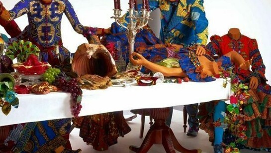 Last Supper (after Leonardo), 13 life-size fibreglass mannequins including a hybrid figure with fur legs and hooves, Dutch wax printed cotton textile, reproduction wooden table and chairs, silver cutlery and vases, antique and reproduction glassware and tableware, fibreglass and resin, 158 x 742 x 260cm, (62 1/4 x 292 1/8 x 102 1/2in)