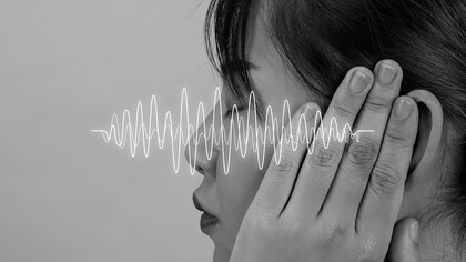 A woman surrounded by sound frequencies, exploring the connection between language and speech sounds