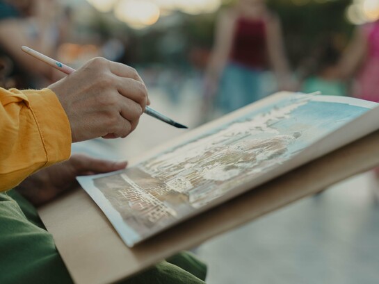 Com pincel em mãos, o artista registra a arquitetura e a atmosfera do espaço urbano. O olhar atento aos cenários faz parte do processo criativo que conduz toda a narrativa. A pintura feita diante da própria paisagem evidencia o diálogo entre observação e criação. Ao longo de seu passeio por Krantournac, François também registra em seu caderno aquilo que mais desperta sua sensibilidade artística
