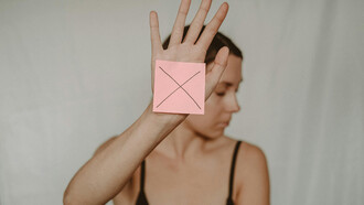 Una giovane donna posa per dire no alla violenza sulle donne