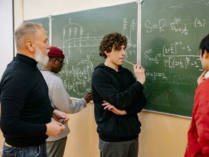 Docente y alumnos frente al pizarrón. Para enfrentar los problemas de la humanidad, es necesario innovar tanto en la metodología de investigación científica como en el paradigma educativo