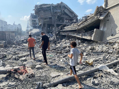 Personas caminan entre los escombros dejados por los bombardeos en la Franja de Gaza