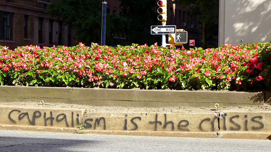 Capitalism is the crisis written on the wall near pavement