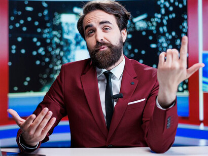 A late-night show host presents fresh newsroom footage and delivers global current affairs, while a media correspondent reports the latest news on a worldwide TV program