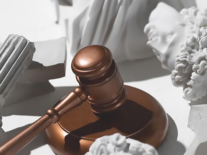 The juxtaposition of a judge's gavel and fallen statues conveys a powerful message about legal decisions and cultural transformations