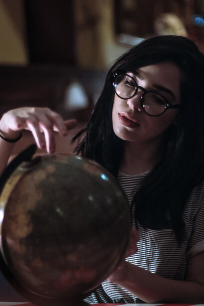 With a sense of wonder and curiosity, a woman holds a globe ball in her hands