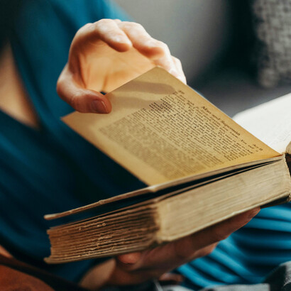 Libro antiguo abierto mientras una persona lo lee