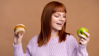 A woman with diabetes carefully deliberating between a hamburger and a donut, making mindful dietary choices to prioritize health