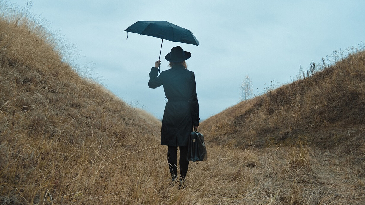 A woman with a suitcase in her hand standing on a path