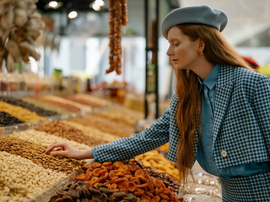 A woman buying seeds and nuts at the market for a healthy lifestyle
