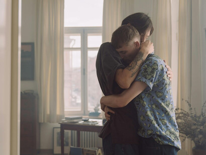Two young men hugging emotively