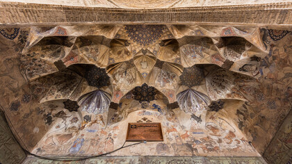 The vaulted ceiling at the entrance of the Ganjali Bathhouse, built in 1631 as part of a larger architectural complex in the old center of Kerman, Iran, features frescoes adorned with Safavid-era ornaments