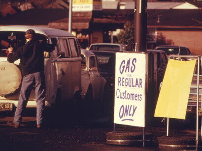 Una bandera en una gasolinera en Portland, Oregón, Estados Unidos, informa a los conductores que la estación vende gasolina solo a clientes habituales, enero de 1974
