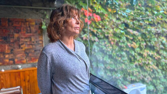 Sylvia Labayru gazes out of the window, her expression reflecting the weight of her past and the complexity of her journey
