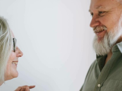 An aging man looks lovingly at his wife 