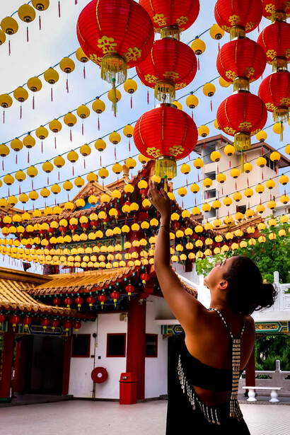 A woman touching a colorful paper lantern in Kuala Lumpur, Malaysia