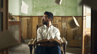 Un hombre rodeado de libros que vuelan por los aires en Beirut, Líbano