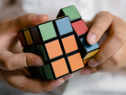 Ce garçon jouant avec le cube Rubik symbolise la manière dont les artefacts externes, comme le Rubik’s Cube, peuvent étendre et modifier les capacités cognitives dans un système cerveau-corps-environnement
