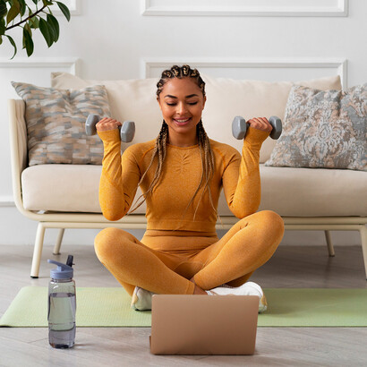 Mulher alongando em casa. Exercícios simples, como alongamentos ou uma rápida caminhada, rejuvenescem a mente e melhoram a circulação