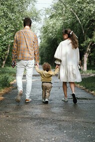 A couple walking in the park with their child