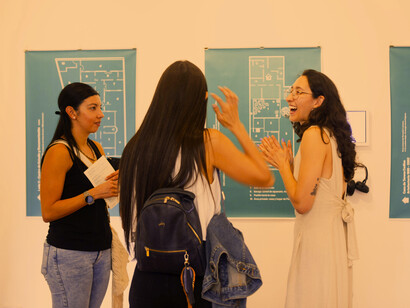 Tres jóvenes comentando la muestra "Territorios domésticos". Fotografía cortesía de Teorética