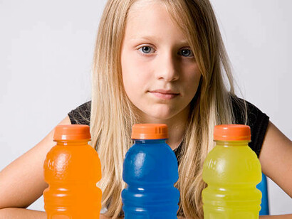 An adolescent holding energy drinks, highlighting the rise of energy drink consumption and addiction among teenagers