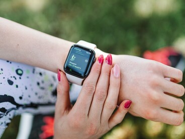 A person checking health and activity readings on a smartwatch, symbolising the role of health awareness in adapting to environmental challenges