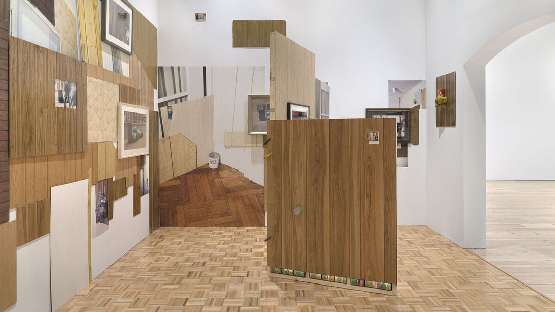 Installation view of Rachel Harrison Life Hack (Whitney Museum of American Art, New York, October 25, 2019–January 12, 2020). Should home windows or shutters be required to withstand a direct hit from an eight-foot-long two-by-four shot from a cannon at 34 miles an hour, without creating a hole big enough to let through a three-inch sphere?, 1996/2019. Photograph by Ron Amstutz