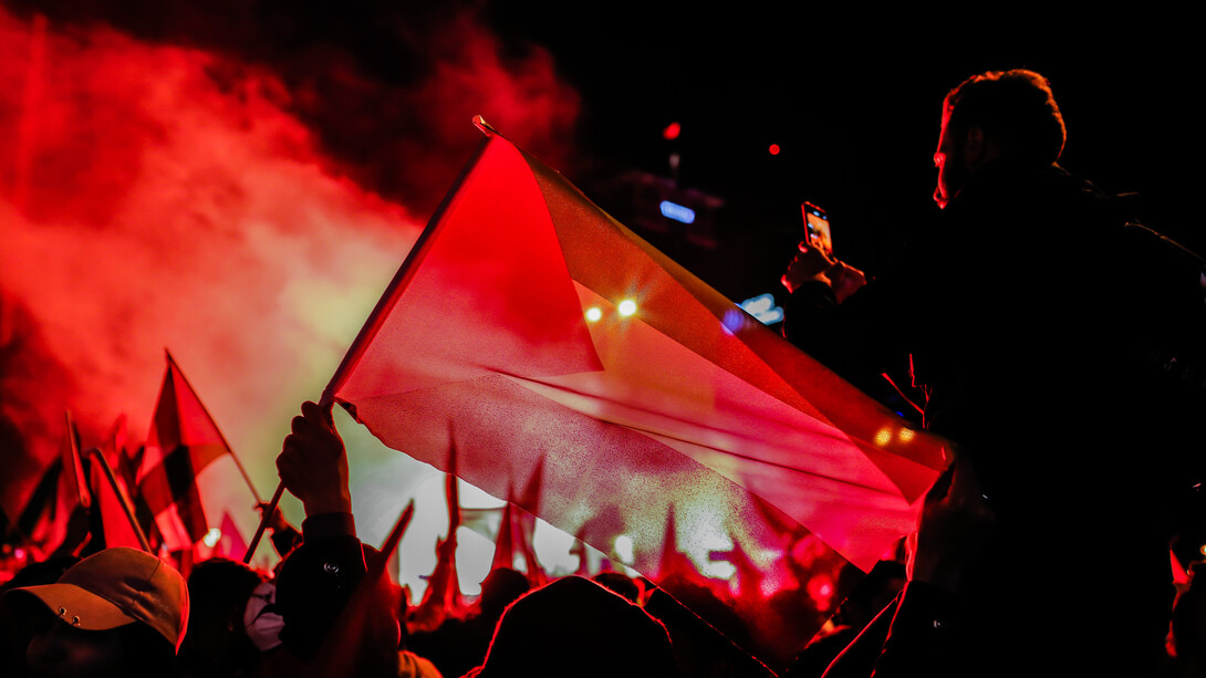 Un hombre alza la bandera de Palestina en una manifestación por el conflicto armado contra Israel