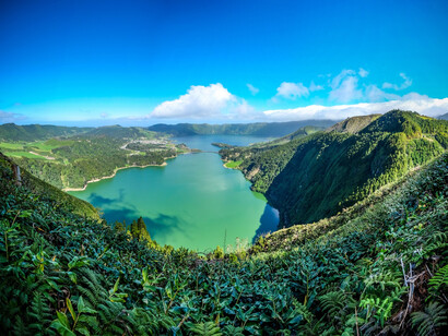 Fascinante vista de lago rodeado de verdes montes bajo el cielo azul. Costa Rica