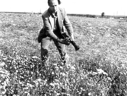 Jonas Mekas in his early days in a field filming daisies