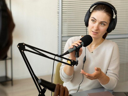 A woman talking on a studio, holding a microphone