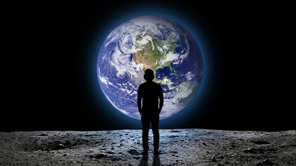 Teenager viewed from behind gazing at planet Earth from outer space