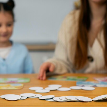 Bambina e adulto che giocano insieme con un gioco da tavolo 