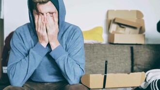 A young person putting their hands to their face because of the amount of stress being experienced