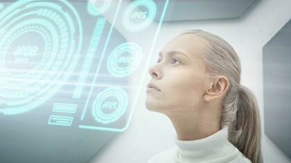 Close-up of a woman studying a glowing screen, reflecting the growing connection between humans and artificial intelligence