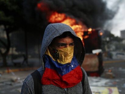 Un encapuchado en una protesta callejera en Venezuela