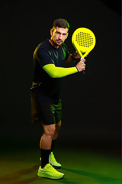 Padel player preparing to hit a shot during an intense indoor match