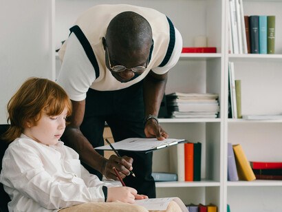 A psychologist assists a young boy with some task