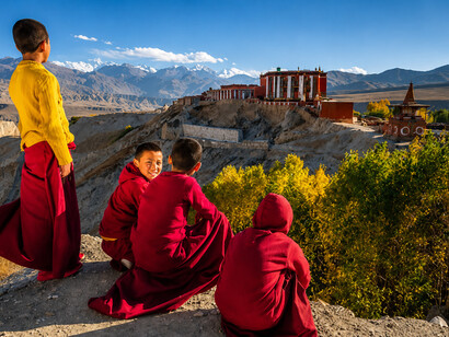 A young Tibetan monk overlooks the rugged mountain scenery of Tsarang Village in Nepal’s Upper Mustang region