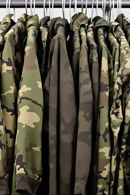 Military uniforms hanging on clothing rack