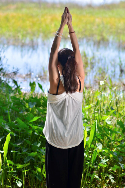 A lady immersed in qigong practice amidst the tranquility of the forest