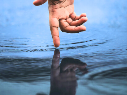 Le contact du doigt avec l'eau évoque l'idée aristotélicienne de l'unité de la matière-puissance, où les limites des entités se confondent dans une continuité naturelle et indivisible