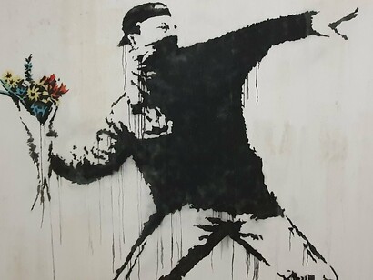 Rage, Flower Thrower (2003), stêncil com tinta spray de Banksy, em Belém, Palestina. Numa época presa ao passado, com medo de mudar, este super-herói retrata momentos duros da história
