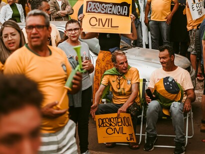Manifestantes se reúnem nas ruas em um período de forte tensão política, marcado pela recusa de setores bolsonaristas em aceitar a derrota eleitoral. Acampamentos diante de quartéis e pedidos de intervenção militar integraram a mobilização que antecedeu os ataques de 8 de janeiro de 2023, quando as sedes dos Três Poderes foram invadidas e depredadas em Brasília