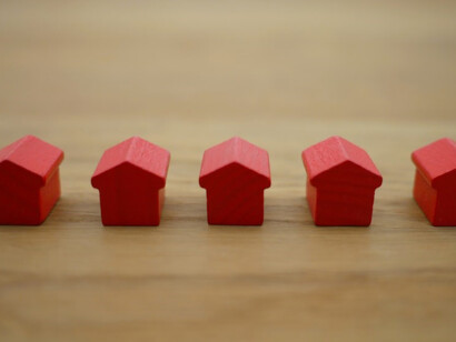 A charming red wooden house miniature rests gracefully atop a rustic brown table